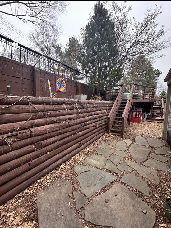 Old leaning wooden timber retaining wall in a residential backyard before replacement by Triple Landscaping