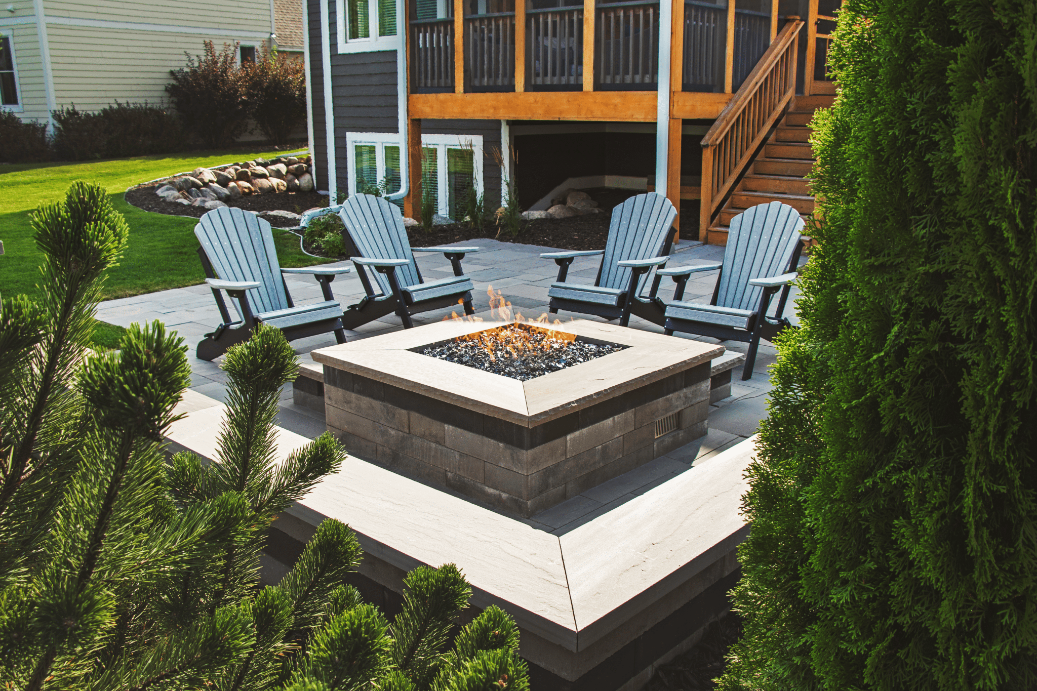 Custom gas fire feature on a paver patio with seating area built by Triple Landscaping in the Twin Cities metro