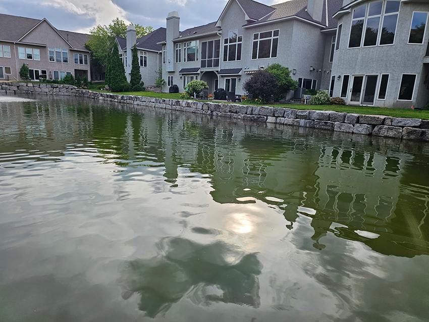 Finished granite boulder lakeshore retaining wall stabilizing the waterfront behind a Twin Cities home by Triple Landscaping