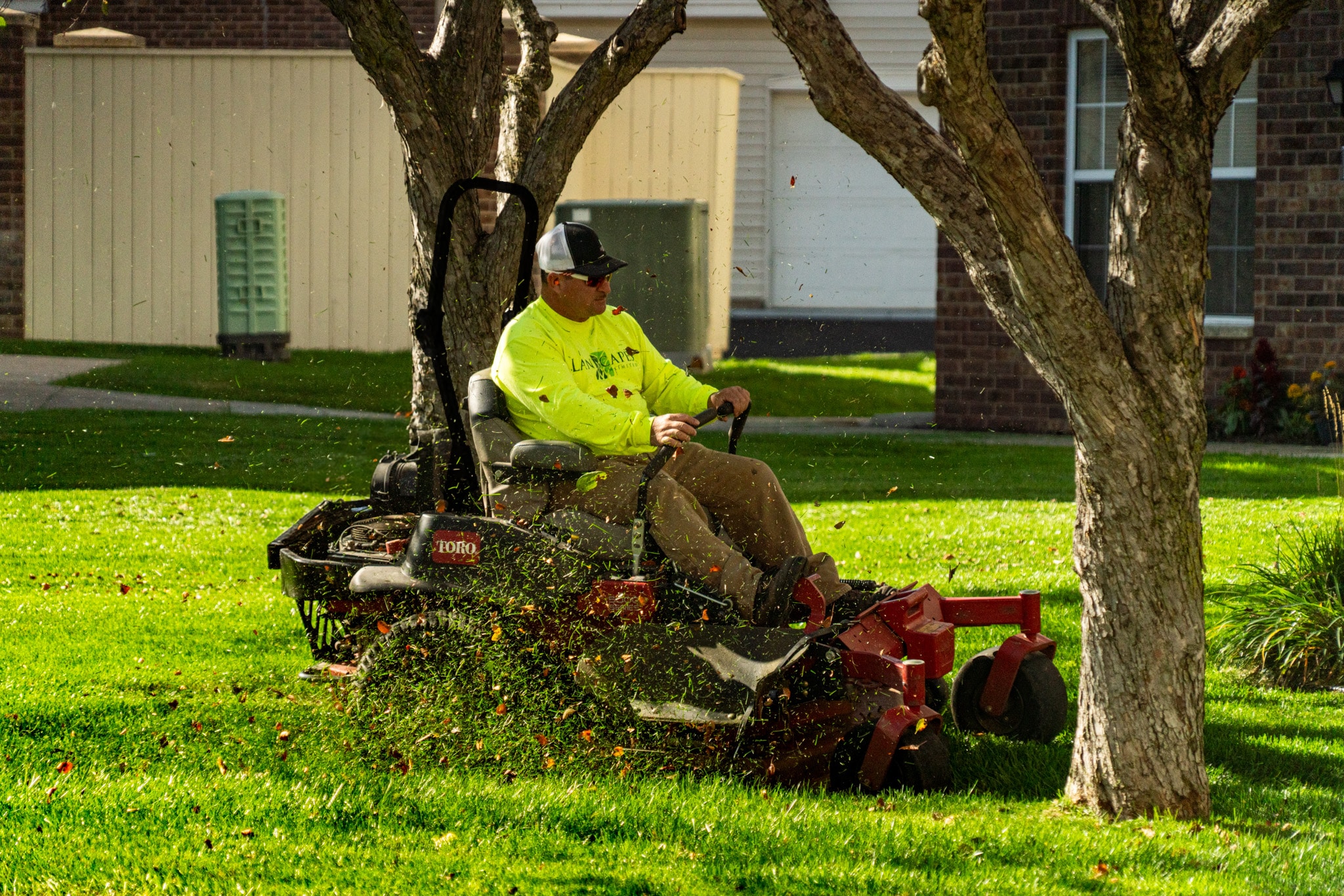 Triple Landscaping crew member operating a Toro zero-turn mower on a commercial lawn in the Twin Cities