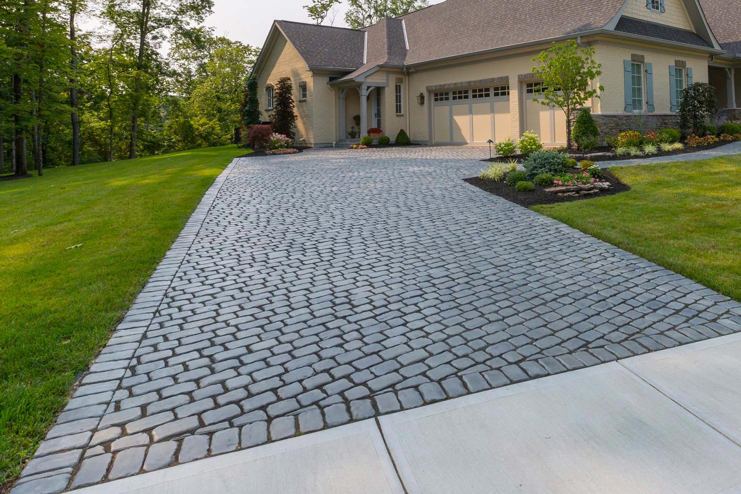 Cobblestone paver driveway leading to a residential garage installed by Triple Landscaping in the Twin Cities
